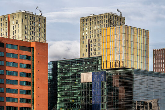 A vibrant blend of colorful modern architectural styles featuring a mix of glass, metal, and brick elements, reflecting diversity and creativity in urban design in Rotterdam