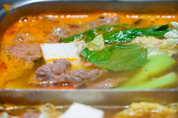 Close up of the quad soup base steamboat. Chinese hot pot. Japanese sukiyaki.A square-sized Chinese hotpot bubbles with savory broth.