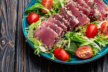 Salad with raw tuna , sesame and cherry tomatoes photography . Top view