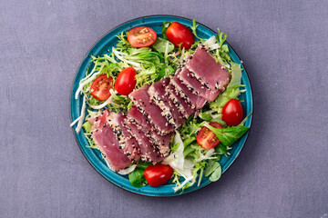 Salad with raw tuna , sesame and cherry tomatoes photography . Top view