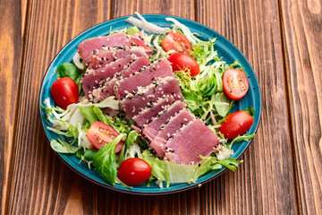 Salad with raw tuna , sesame and cherry tomatoes photography . Top view