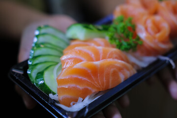 Salmon sashimi in plastic box packaging tray ready to eat.