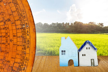 Old wooden Chinese feng shui compass over rice field in Thailand background, property industry,...