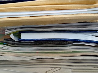 Stack of papers, files, data, books in a shelf in a office drawer.