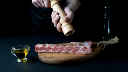 chef adding spices to meat ribs