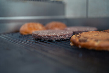 Burger patties sizzling on a hot grill, with smoke rising and a golden-brown crust forming.
Burger patties sizzle on a hot grill, with smoke rising and a golden-brown crust forming.