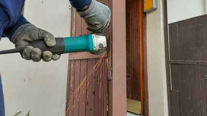A worker uses an angle grinder to cut metal, illustrating the concept of home repair and maintenance projects