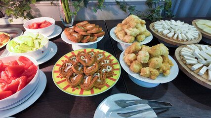 A vibrant Mediterranean buffet table with fresh vegetables, cheese, and pastries, perfect for celebrating Easter with a Greek culinary twist