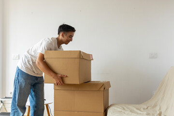 Trans man packing boxes in new home