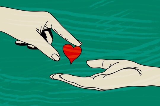 Hands giving a red heart on a green background