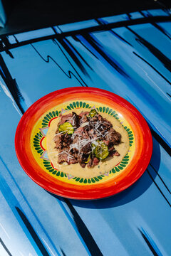 Roast beef with tonnato sauce served with cucumber on Colorful Plate