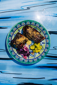 Spareribs served with colorful sides on a patterned plate