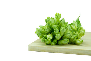 Close up of Fresh Cowslip Creeper (Telosma Cordata) Flowers and green leaves on wooden cutting board isolated on white background with clipping path stacking