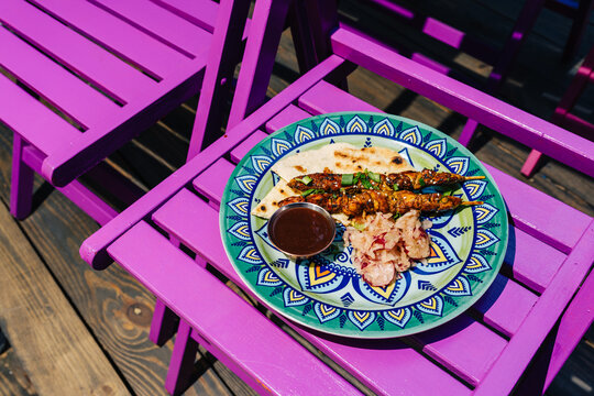 Chicken hearts yakitori served on colorful plate outdoors