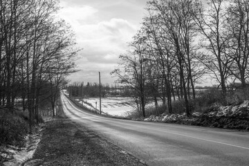 Black and white photo of an empty country road in late winter Ontario, Canada