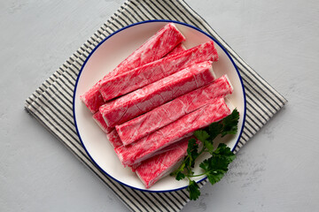 Organic Imitation Crab Meat Sticks on a Plate, top view. Flat lay, overhead, from above.