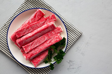 Organic Imitation Crab Meat Sticks on a Plate, top view. Flat lay, overhead, from above. Copy space.