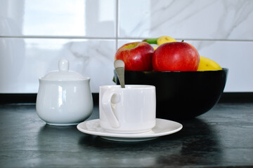 A close-up of a cup of coffee on the kitchen counter. A cozy detail that highlights the atmosphere of home comfort and the joy of simple pleasures.