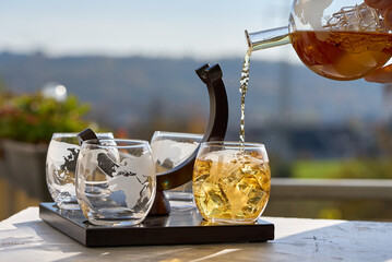 The bartender pours whiskey into a globe glass