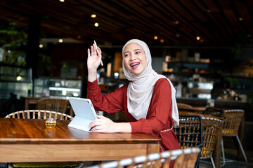 Young Woman in Cafe Using Tablet and Smiling