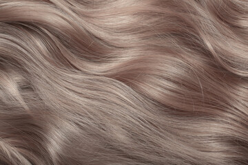 Naklejka premium Blond hair close-up as a background. Women's long light brown hair. Beautifully styled wavy shiny curls. Hair coloring. Hairdressing procedures, extension.
