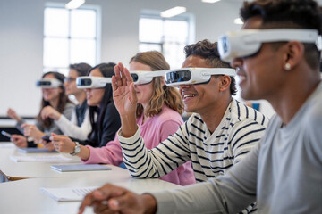Students raising hands and wearing vr headsets in classroom
