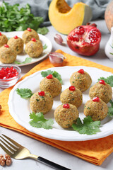 Traditional Georgian appetizer pkhali from pumpkin garnished with pomegranate seeds on light gray background. Vertical format.