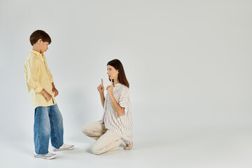 A caring mother kneels down to engage with her son who has a hearing impairment.