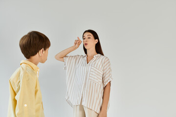 Fototapeta premium A mother guides her hearing impaired child in learning expression through sign language.