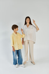 A mother and her son express themselves through sign language in a warm, affectionate moment.