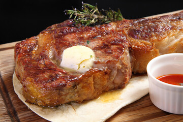 Steak placed on pita bread on a special wooden board. Beef steak on a wooden board.