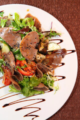 Beef tongue salad with herbs and spices on a white plate. Beef tongue dish.