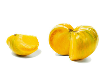 Yellow whole and cut farm tomato on white.