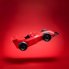 a red toy race car floating or flying isolated on Clean Red background