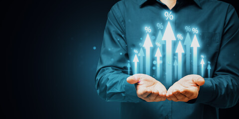 Close up of male hands holding growing glowing interest arrows on dark background with mock up place. Benefit, market and increase concept.