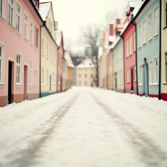 Obraz premium Snow-covered street lined with pastel-colored buildings in winter.