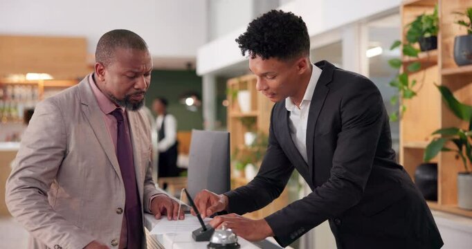 Receptionist, man and discussion for check in, welcome and help desk with friendly service. Happy people, businessman and employee with customer, hospitality or holiday with hotel, lodge and vacation