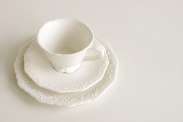 White ceramic coffee cup and sausers set  isolated on white background. Elegant classic porcelain utensils.Copy space . Business food brand template.