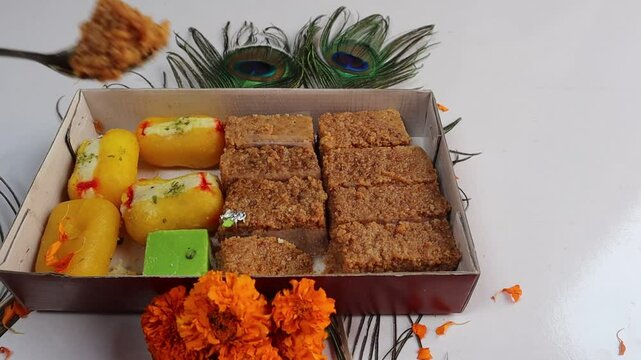 A tray of Indian sweets, chamcham and sponge milkcake, displayed on a white background, highlighting their delicate textures and appealing appearance, selective focus 