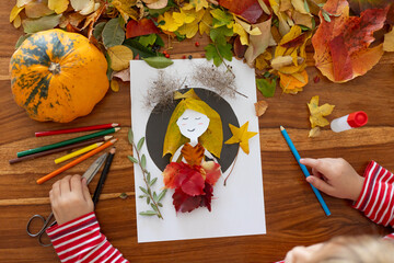 Sweet child, boy, applying leaves using glue while doing arts and crafts at home