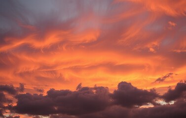 Naklejka premium Clouds in shades of fiery orange and smoky gray