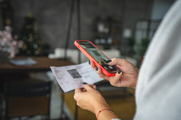 Back view of woman do contactleess payment on cellphone and pay bills
