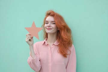 A woman with vibrant red hair holds a paper star aloft, symbolizing hope and positivity