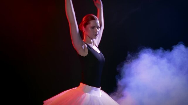 Beauty and grace of young pretty ballerina dancing alone on theatre stage. Full-length portrait of slender woman in white tutu and pointe shoes white lightning studio, classic dance and choreography