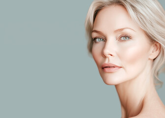 Fototapeta premium portrait of a beautiful 50 year old woman with blond hair, blue eyes and soft glowing skin