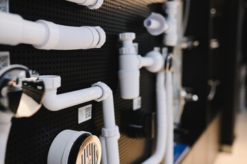 many different white plastic bath drain systems on store display