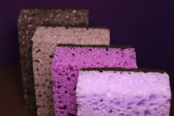 stylish dark sponges for washing dishes and cleaning on a purple background