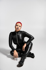 A confident young woman in a sleek black outfit expresses her unique fashion sense in an artistic studio.