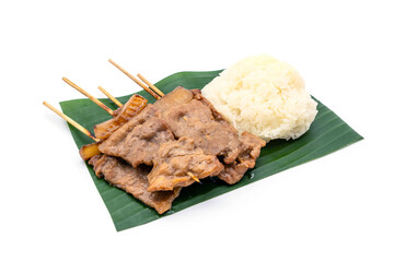 Thai Street food Available Available at the market and corners everywhere. Set Sticky rice with grilled pork on a stick on a banana leaf isolated on white background.