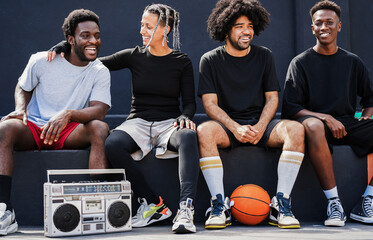 Group of young multiracial people listening music from vintage boombox stereo outdoor after...